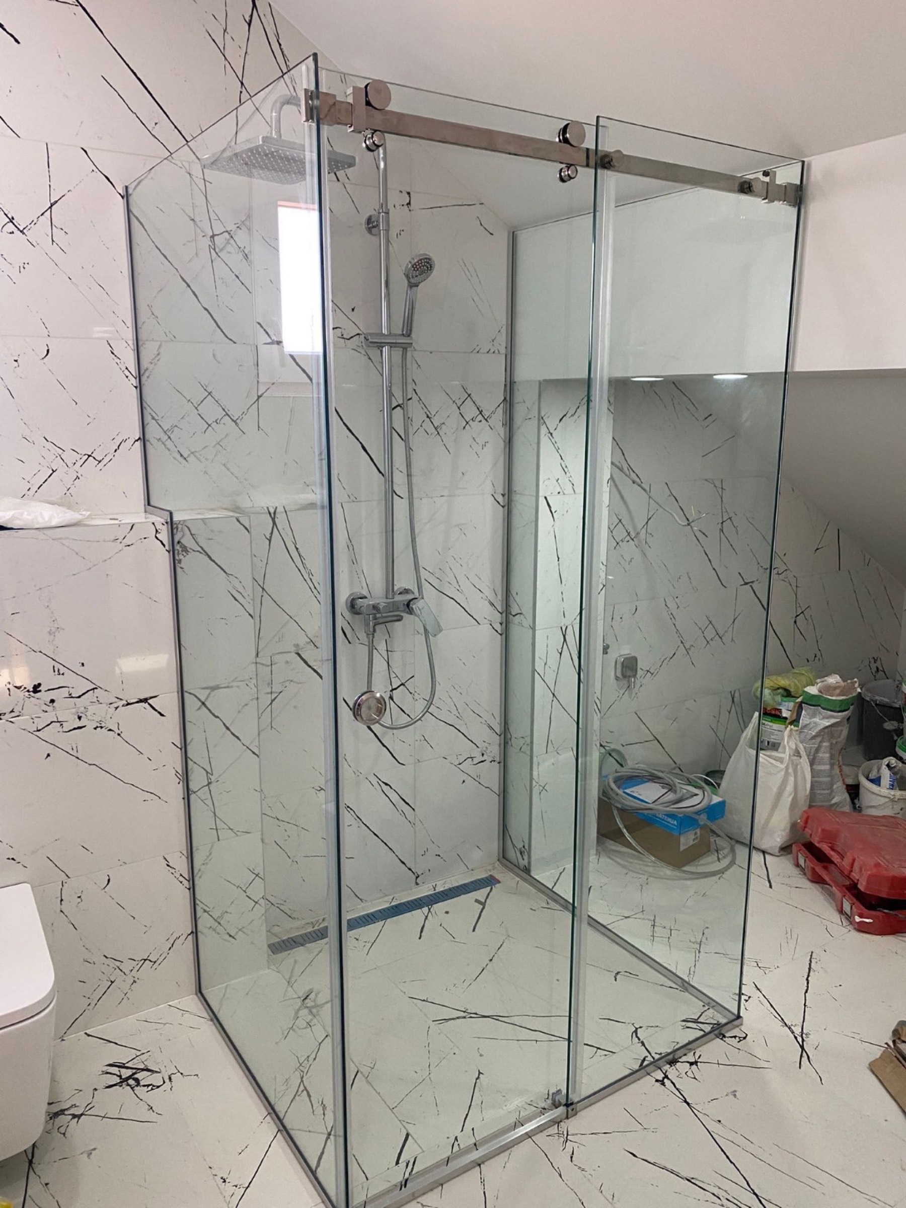 Seitliche Ansicht der Glasdusche mit grossformatigen Wandfliesen